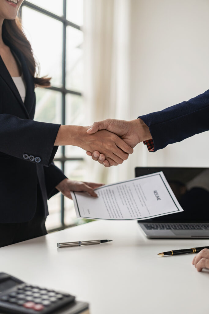 Executives shake hands with job applicants and read job applicant profiles to match the job positions. The company publishes online job vacancies to find people. human resources interview successful